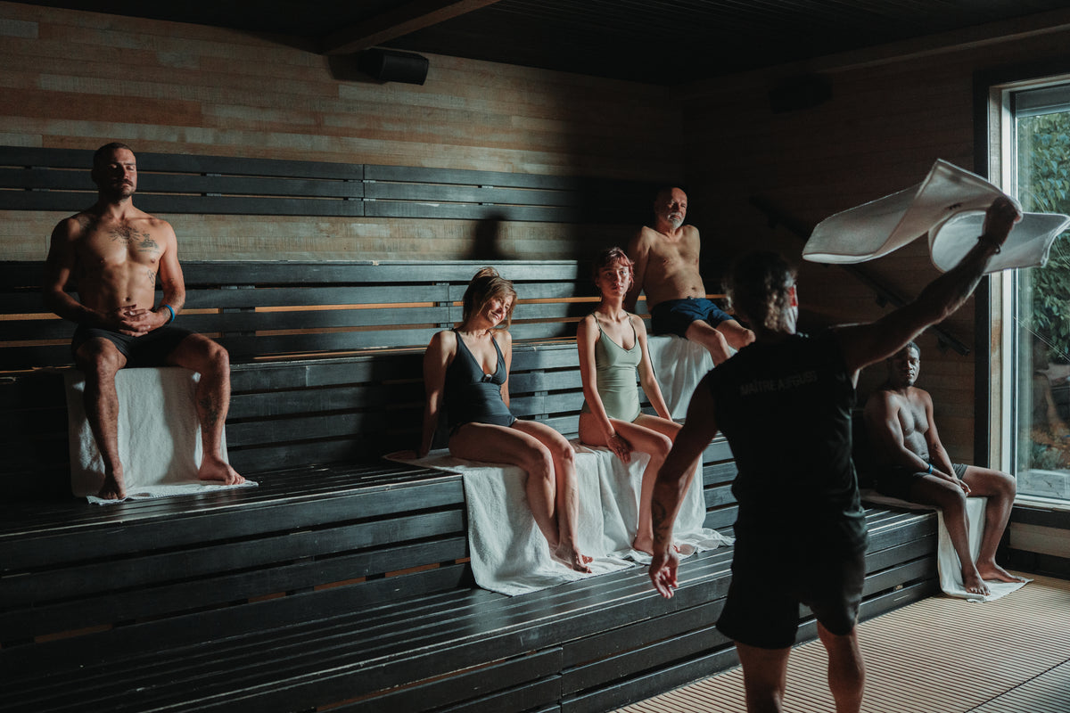 Expérience thermale : personnes assises en sauna sur banquettes en bois
