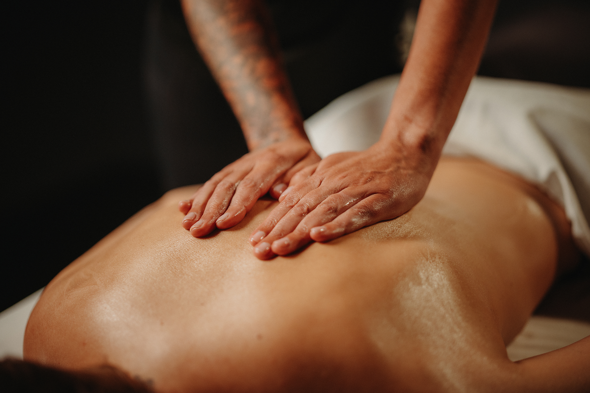 Séance de massage californien : pression des mains sur le haut du dos, gros plan