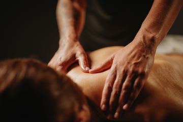 Massage de drainage lymphatique sur l’épaule et le haut du dos, mains massantes