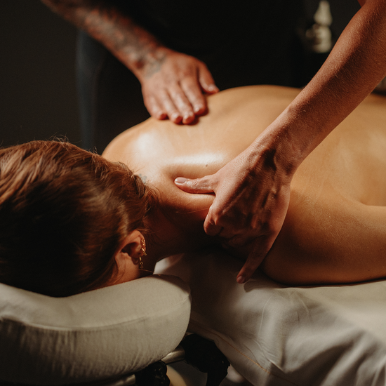 Massage thérapeutique du dos, mains sur la nuque et les épaules, sur table