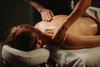 Massage thérapeutique du dos, mains sur la nuque et les épaules, sur table