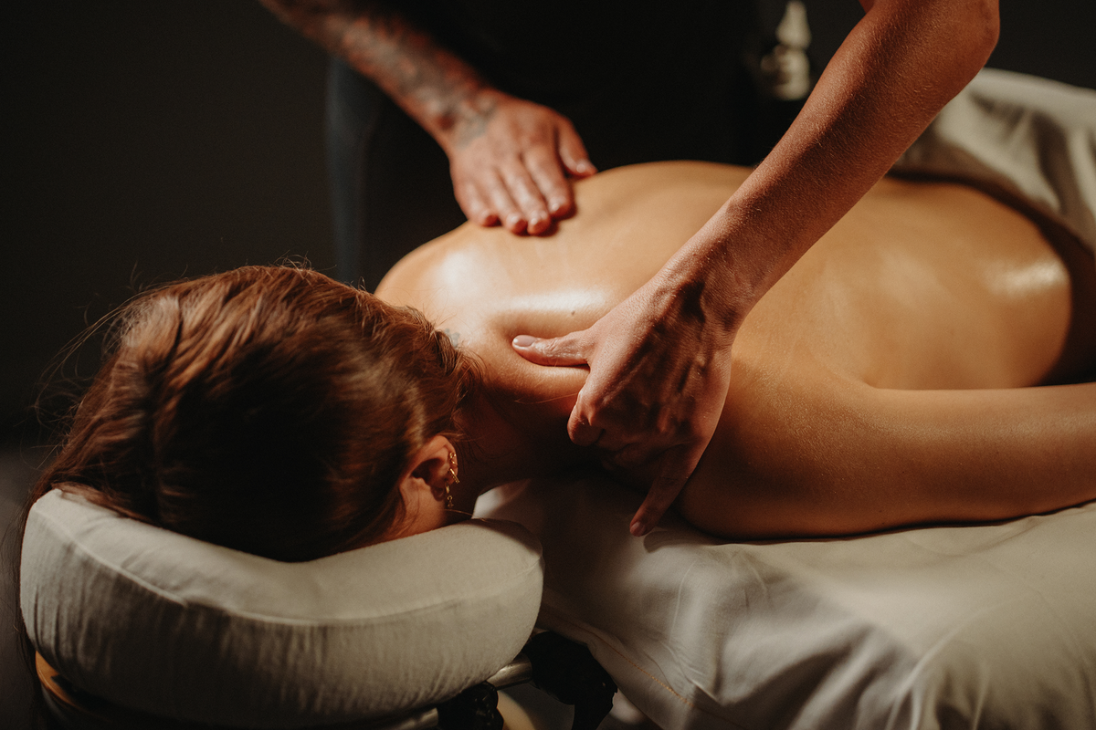 Massage thérapeutique du dos, mains sur la nuque et les épaules, sur table