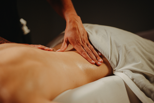 Massage de tissus profonds : mains pressant le dos, allongé sur le ventre