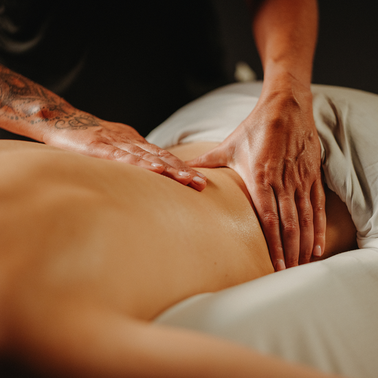 Massage de drainage lymphatique sur le dos, mains du praticien en appui