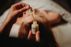 Huile de massage cheveux : flacon et pipette appliqués sur le cuir chevelu