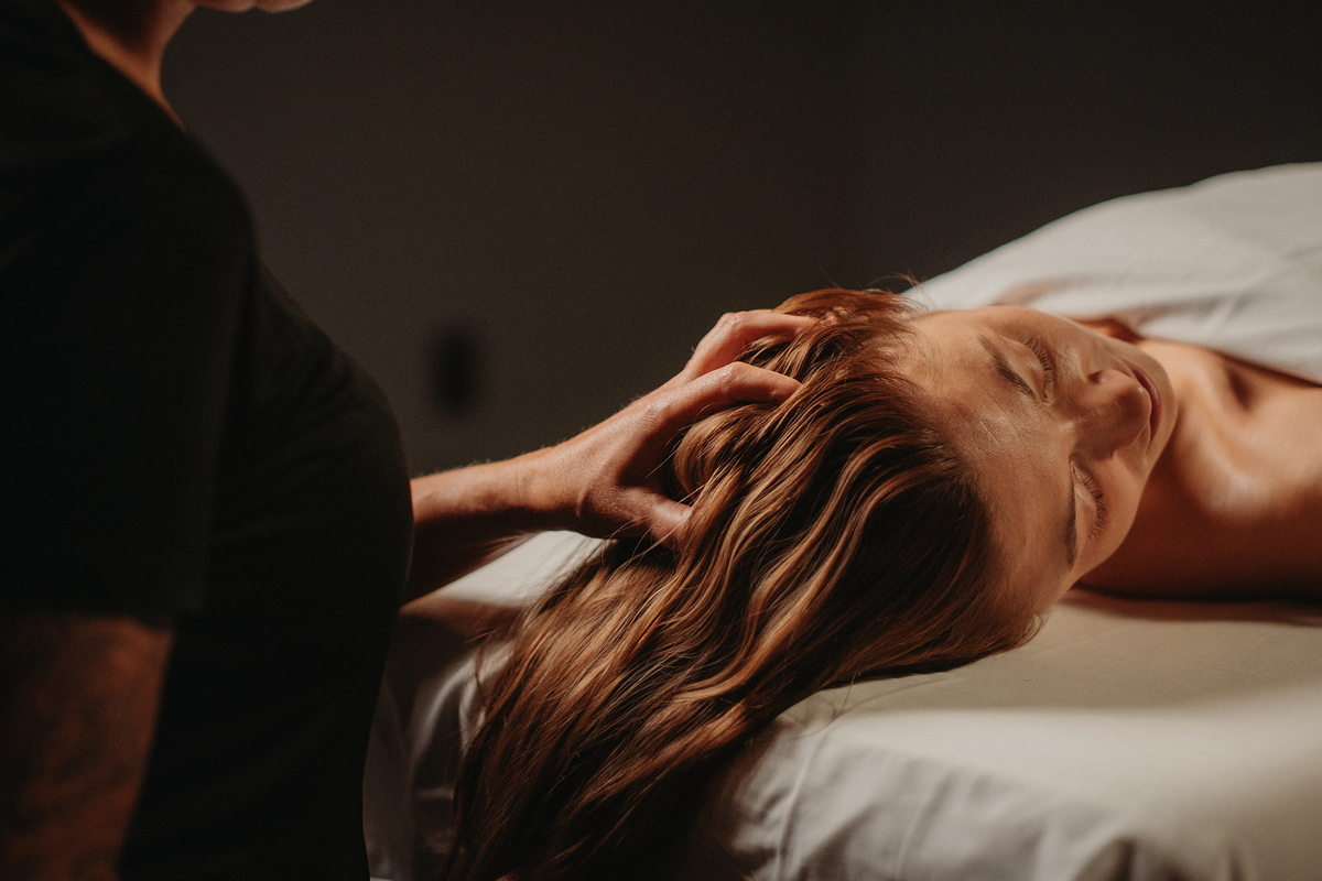 Massage des cheveux sur table : praticien massant les mèches d’une cliente