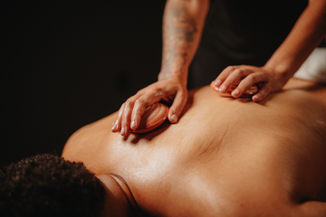 Massage de coquillages chauffants : coquillage chaud sur le dos, mains en action.