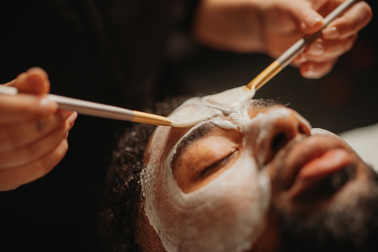 Soin du visage douceur : masque blanc appliqué au pinceau sur le visage d’un homme