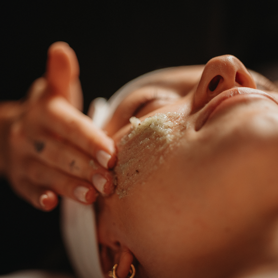 Soin visage hydratant : produit exfoliant aux grains étalé sur le front