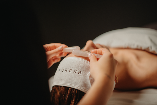 Soin du visage iridescence : gua sha translucide sur le front, serviette en éponge