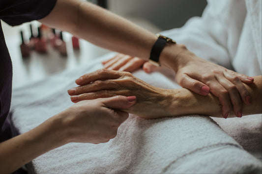 Soin des mains : mains allongées pendant un soin, application de vernis gel