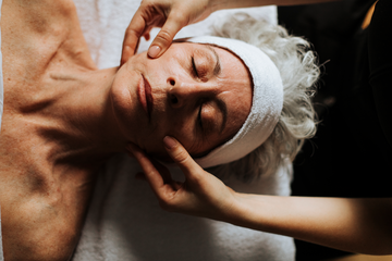 Soin visage lifting naturel avec massage du visage, serviette blanche sur le client.
