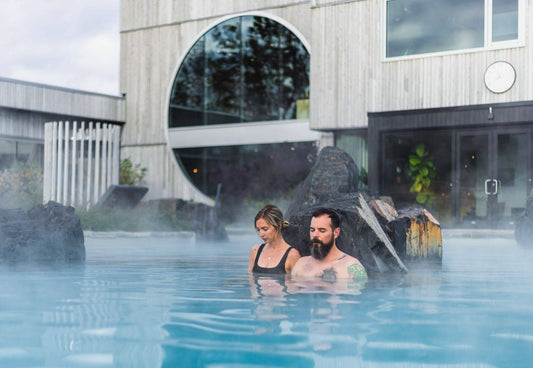 Forfait feu : accès à un bain chaud extérieur avec vapeur, deux personnes se baignent.